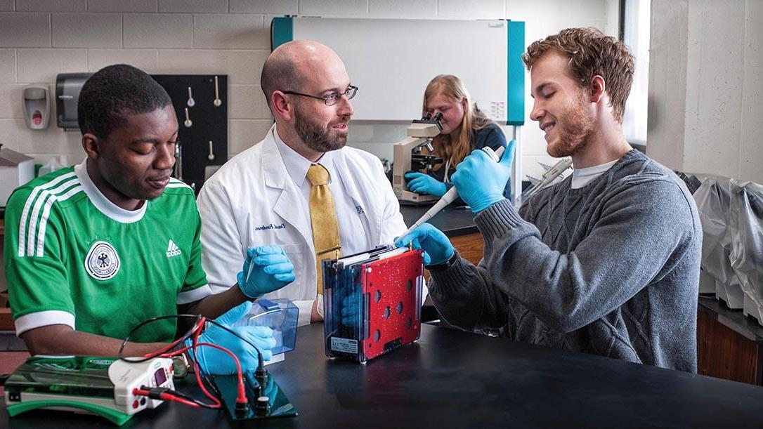 Chemistry teacher helping students place chemicals into beakers.